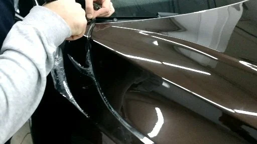 Аккуратная укладка защитной пленки на сложной детали кузова