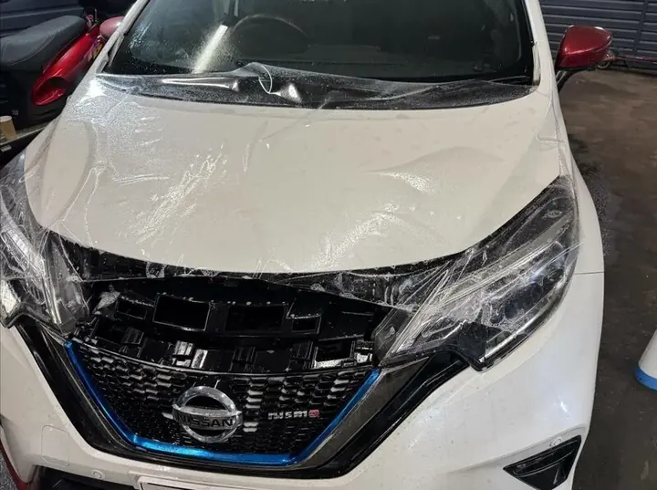 Осмотр состояния пленки на капоте автомобиля перед переклейкой