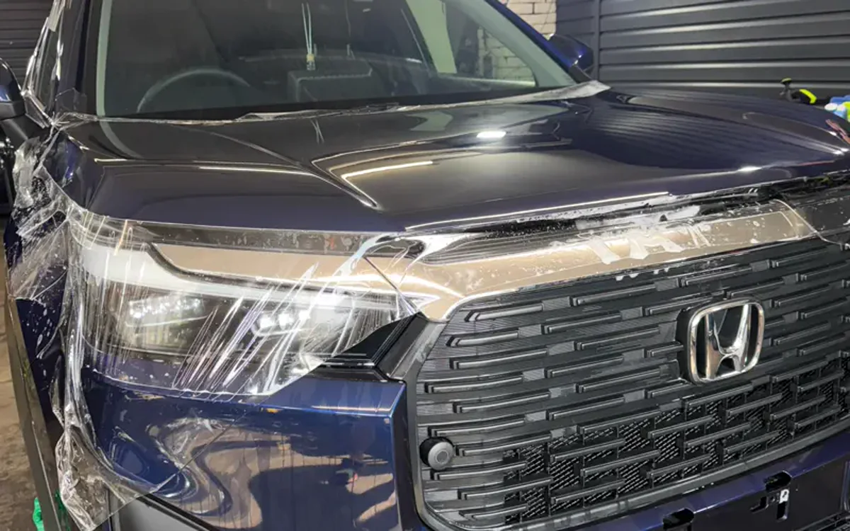 Передняя часть Honda с защитной плёнкой во время монтажа
