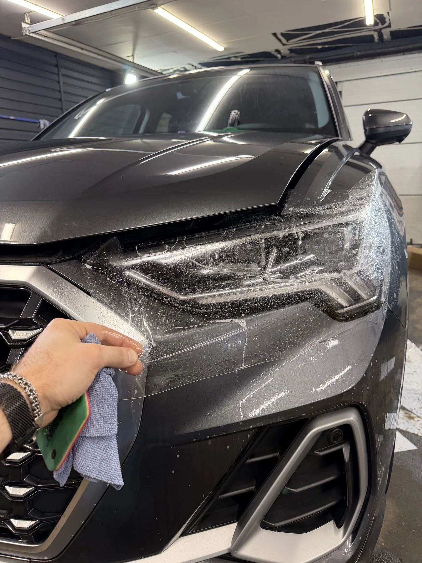 Оклейка зон риска Audi Q3 2026 защитной пленкой - укладка защитной пленки на деталь
